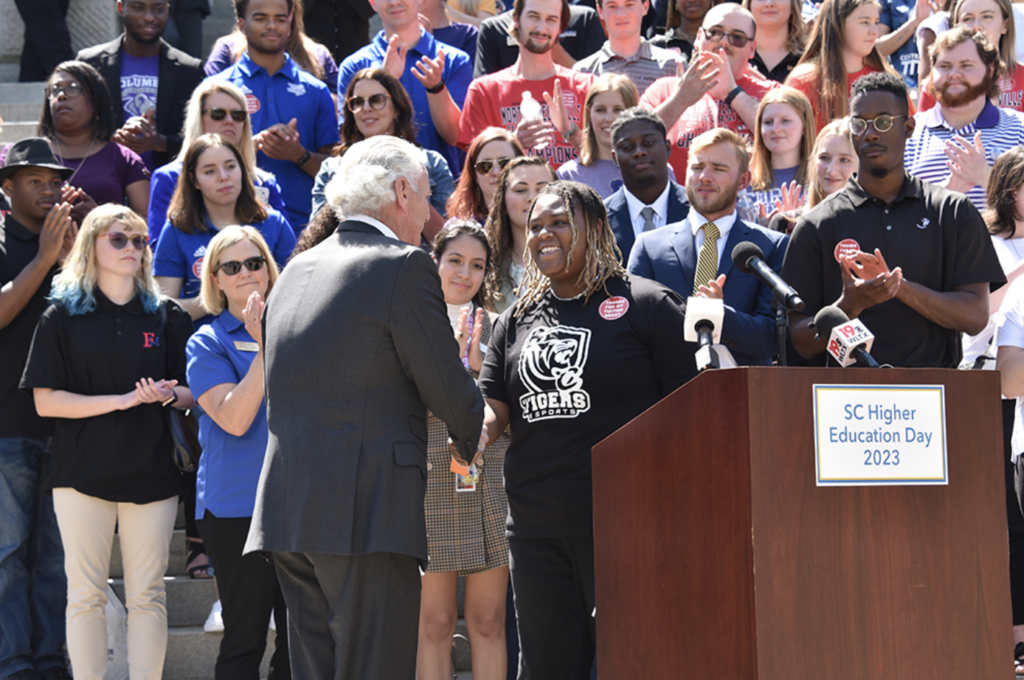 Benedict College’s Kylah Montgomery (behind podium), the SCICU featured student speaker for Higher Education Day, introduced and welcomed Gov. Henry McMaster (left of Montgomery) to the podium for the Proclamation Ceremony.
